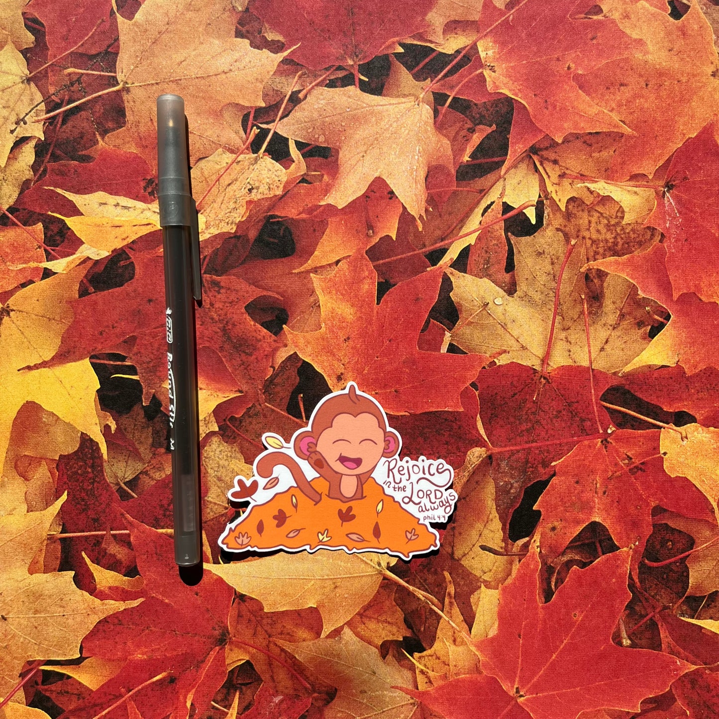 monkey in leaves sticker next to a pin for scale