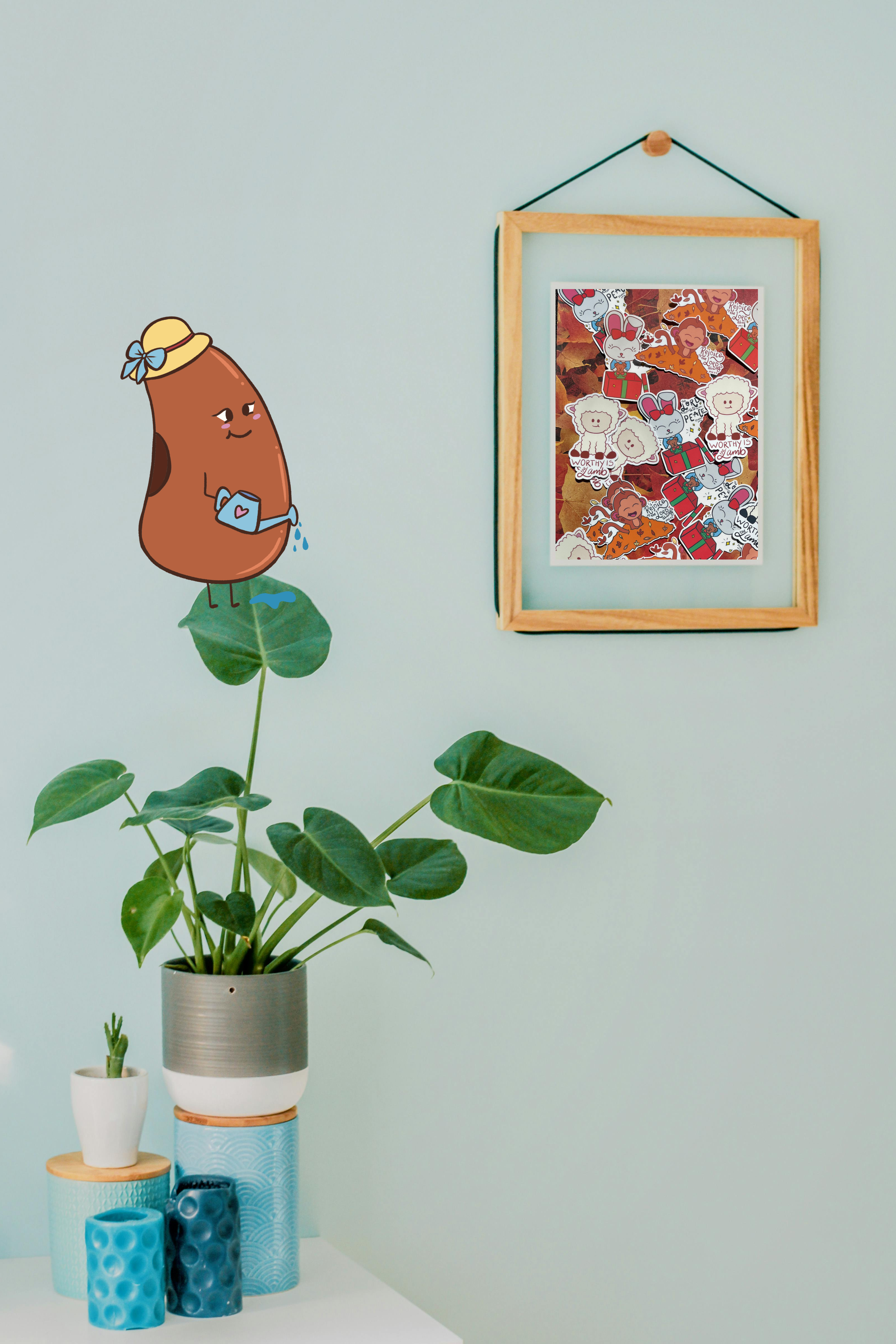 Decorative plant in a pot with a framed artwork on a light blue wall.